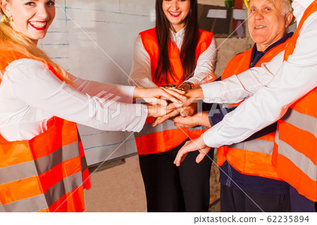 Workers at the industrial plant are standing in a circle 62235894