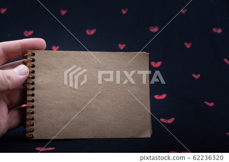Spiral notebook on background with red hearts Spiral notebook on background with red hearts 62236320