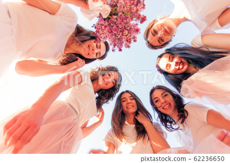 Happy young bridesmaids looking down together, bottom vew 62236650