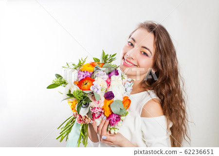 Young happy mother enjoying flowers bouquet in hands 62236651