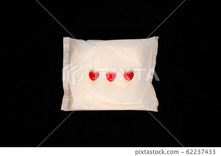 Irregular period concept. Menstrual cycle pad with red hearts on black background. Menorrhagia or heavy menstruation bleeding. Feminine critical days hygiene products. Creative minimalism dark photo Irregular period concept. Menstrual cycle pad with red hearts on black background. Menorrhagia or heavy menstruation bleeding. Feminine critical days hygiene products. Creative minimalism dark photo 62237433