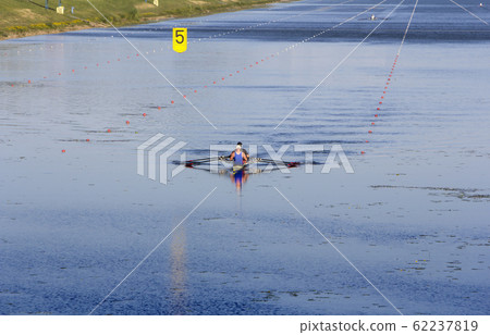 Two man in a sports boat rowing on the lake Two man in a sports boat rowing on the lake 62237819