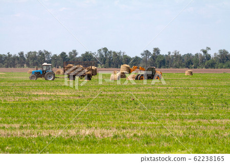 Tractor loading hay bales on truck agricultural works Tractor loading hay bales on truck agricultural works 62238165