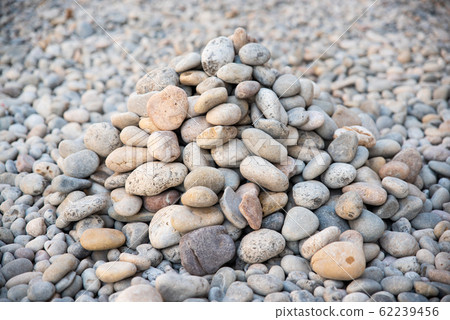 Heap of sea pebbles made by travelers on a seashore, close-up. Natural summer background with soft copy space Heap of sea pebbles made by travelers on a seashore, close-up. Natural summer background with soft copy space 62239456