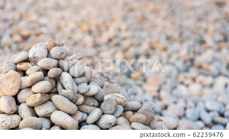 Heap of sea pebbles on a shore, close-up. Natural summer background with soft copy space. Summer time theme 62239476