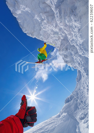 Skier jumping against blue sky from the rock Skier jumping against blue sky from the rock 62239607