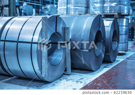 Industrial background. Big size steel coil stored inside industrial warehouse, blue toned image. 62239636