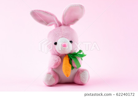 toy pink rabbit on a pastel pink background with a toy pink rabbit on a pastel pink background with a 62240172