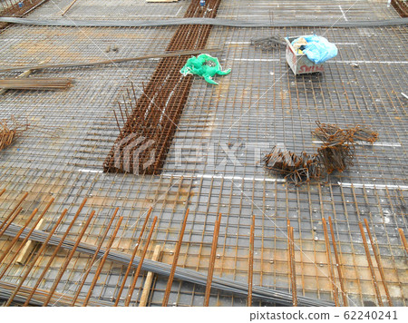 KUALA LUMPUR, MALAYSIA -JUNE 16, 2018: Floor slab and beam reinforcement bar under construction to form reinforcement concrete. Construction workers tied it together using tiny wires. KUALA LUMPUR, MALAYSIA -JUNE 16, 2018: Floor slab and beam reinforcement bar under construction to form reinforcement concrete. Construction workers tied it together using tiny wires. 62240241