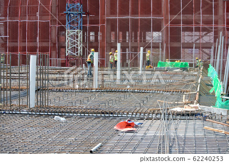 KUALA LUMPUR, MALAYSIA -JUNE 16, 2018: Floor slab and beam reinforcement bar under construction to form reinforcement concrete. Construction workers tied it together using tiny wires. KUALA LUMPUR, MALAYSIA -JUNE 16, 2018: Floor slab and beam reinforcement bar under construction to form reinforcement concrete. Construction workers tied it together using tiny wires. 62240253