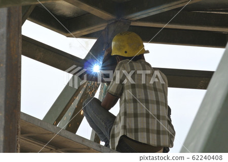 Welder wearing protective mask welding mild steel metal at the construction site on August 07, 2014 at Selangor, Malaysia. 62240408