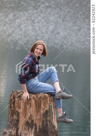beautiful girl sitting on a stump beautiful girl sitting on a stump 62242823