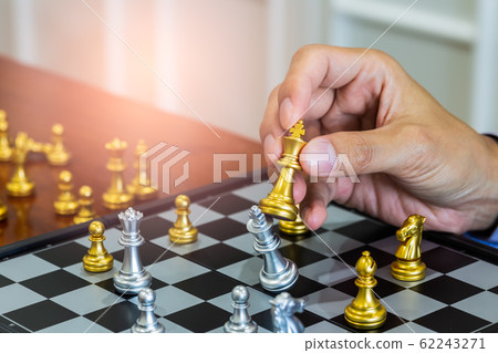 Chess game on chess board behind business man 62243271