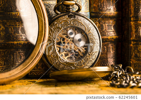 Antique clock on the background of a magnifying 62245601