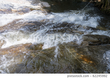 Calm water stream around the rocks 62245992