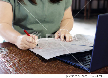 hand holding pen marking on paperwork in office hand holding pen marking on paperwork in office 62247985