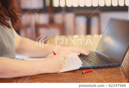 hand holding pen marking on paperwork in office 62247986