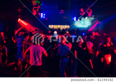 blurred silhouettes of people dancing in a nightclub 62249192
