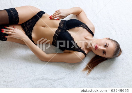 Sexy model with perfect body lying on white blancket. Sexy model with perfect body lying on white blancket. 62249665