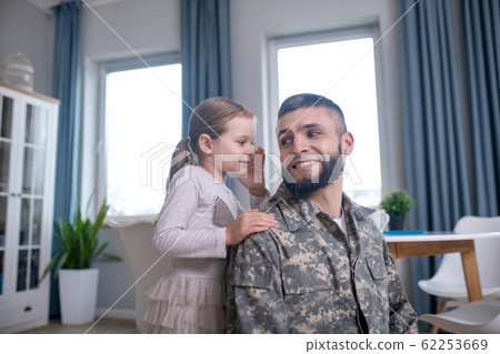 Little daughter whispering in the ear of her dad. Little daughter whispering in the ear of her dad. 62253669