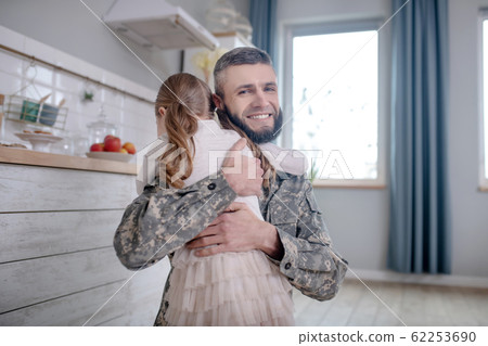 Serviceman dad returning home hugging little daughter. 62253690