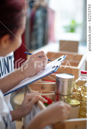 Products for people in need folded in a donation box. Products for people in need folded in a donation box. 62253743