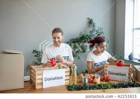Young people volunteers working in a charity. Young people volunteers working in a charity. 62253815