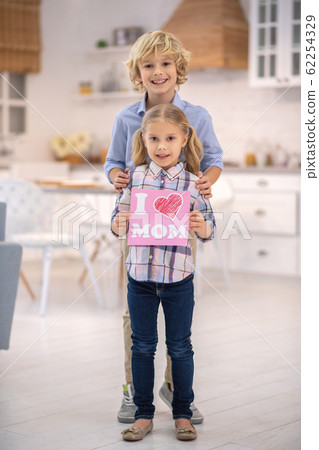 Cute kids standing together and holding sign 62254329