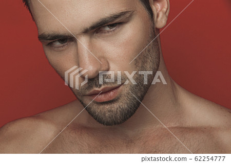 Muscle strong beautiful stripped male model in white casual suit on red isolated font background  62254777
