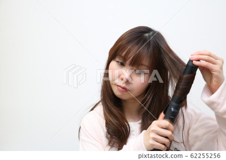 使用頭髮鐵的婦女 使用頭髮鐵的婦女 62255256