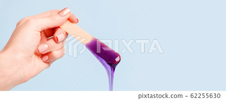 Hand holding beauty purple wax or sugar paste on Hand holding beauty purple wax or sugar paste on 62255630