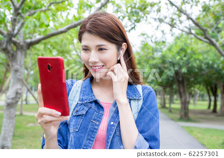 asian girl use phone outdoor 62257301