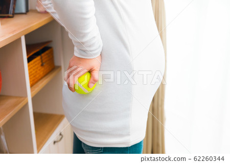 Pregnant woman with back pain tennis ball 62260344
