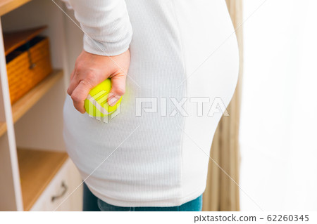 Pregnant woman with back pain tennis ball 62260345