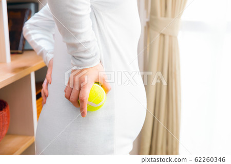 Pregnant woman with back pain tennis ball 62260346