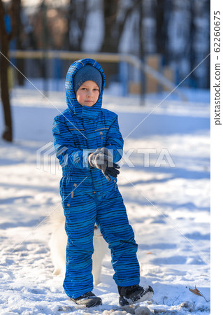 Small boy training a spitz dog in the park 62260675