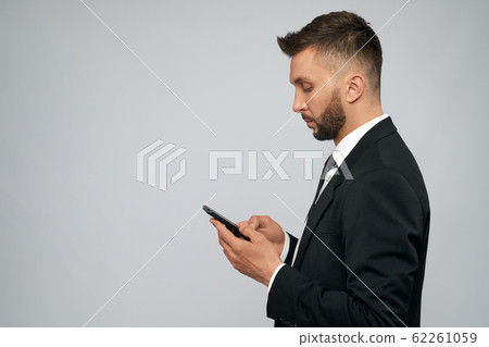 Young businessman using smartphone. 62261059