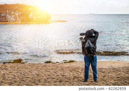 Photographer traveler with a camera and a backpack 62262939