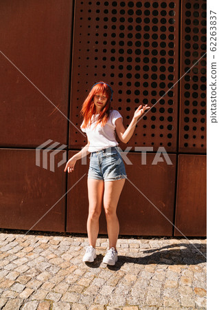 Young woman moves in dance on sunny street alone Young woman moves in dance on sunny street alone 62263837