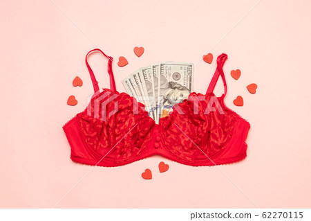 Red lace bra with a bundle of money on a pink 62270115