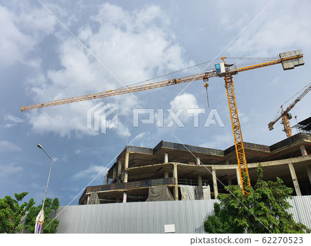 BANGKOK, THAILAND- October 14, 2019: Tower crane in construction site against cloud and blue sky at BANGKOK, THAILAND. BANGKOK, THAILAND- October 14, 2019: Tower crane in construction site against cloud and blue sky at BANGKOK, THAILAND. 62270523