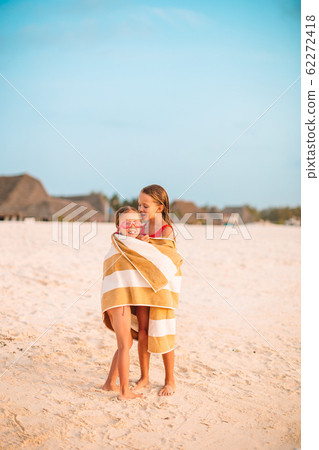 Little cute girls wrapped in towel at tropical beach. Kids on the beach vacation 62272418