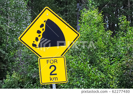 A warning falling rocks for two km sign A warning falling rocks for two km sign 62277480