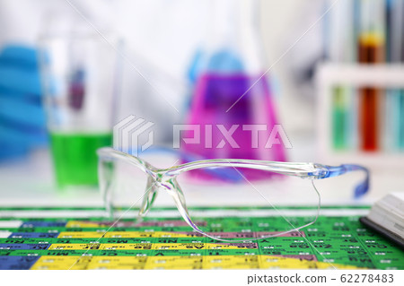 Protective surgical or lab glasses lying on periodic table 62278483