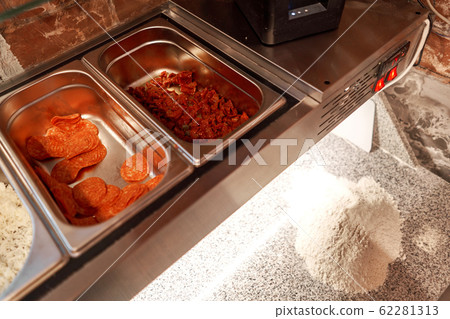 Filling semi-finished products for cooking pizza in cold table for blanks. Traditional wood oven in restaurant, Italy. Original neapolitan pizza. Red hot coal. Filling semi-finished products for cooking pizza in cold table for blanks. Traditional wood oven in restaurant, Italy. Original neapolitan pizza. Red hot coal. 62281313