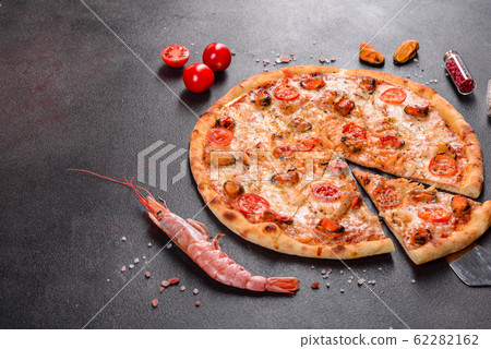 Tasty sliced pizza with seafood and tomato Tasty sliced pizza with seafood and tomato 62282162