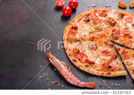 Tasty sliced pizza with seafood and tomato Tasty sliced pizza with seafood and tomato 62282163