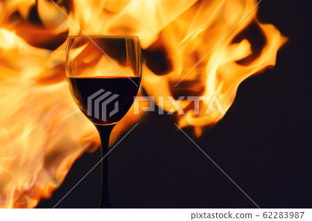 glass of red wine in the flame. horizontal. glass of red wine in the flame. horizontal. 62283987