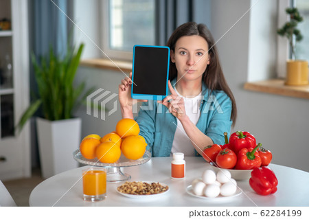 Woman using a tablet while being on a diet Woman using a tablet while being on a diet 62284199