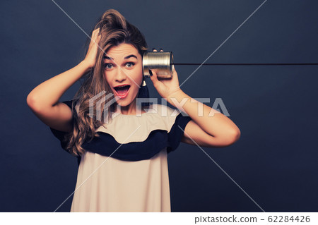 portrait of young surprised woman hearing through portrait of young surprised woman hearing through 62284426